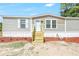 Charming home featuring a front entrance with wooden steps and red landscaping at 9055 Atlas Dr, St Cloud, FL 34773
