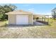 View of the garage featuring a roll up door and attached carport with a concrete slab foundation at 9055 Atlas Dr, St Cloud, FL 34773
