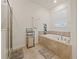 Bright bathroom featuring a soaking tub, separate shower, and neutral decor for a relaxing atmosphere at 9084 Sommerset Hills Dr, Davenport, FL 33896