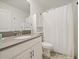 Bright bathroom features a modern vanity with a gray countertop and white cabinets and fixtures at 9084 Sommerset Hills Dr, Davenport, FL 33896