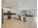 Open-concept kitchen with white cabinets, stainless steel appliances, and a seamless transition to the living area at 9084 Sommerset Hills Dr, Davenport, FL 33896