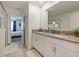 Bathroom features a double sink vanity and an open doorway to a bedroom with a queen bed at 9084 Sommerset Hills Dr, Davenport, FL 33896
