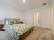 Bright bedroom with a king-sized bed, neutral carpet, and a view of the hallway, offering style and comfort at 9084 Sommerset Hills Dr, Davenport, FL 33896