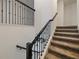 Carpeted staircase with decorative wrought iron railing, providing an elegant transition between floors at 9084 Sommerset Hills Dr, Davenport, FL 33896