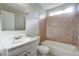 A bathroom with a tub-shower combo, vanity, and tiled walls and floors at 9447 Dearmont Ave, Orlando, FL 32825