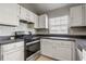 A cozy kitchen with white cabinets, a dark countertop, and essential appliances for a functional cooking space at 9447 Dearmont Ave, Orlando, FL 32825