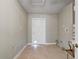 A functional laundry room with a white door, tile floors, and space for laundry appliances at 9447 Dearmont Ave, Orlando, FL 32825