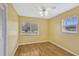 Cozy bedroom with hardwood floors, a ceiling fan, and natural light from two windows at 1001 Dora Ave, Tavares, FL 32778