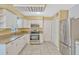 Well-lit kitchen featuring white cabinets, granite countertops, and stainless steel appliances at 1001 Dora Ave, Tavares, FL 32778
