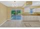 Bright kitchen featuring white cabinets, granite countertops, tile flooring, and access to the patio at 1001 Dora Ave, Tavares, FL 32778