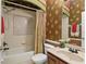 Bathroom featuring a shower with decorative tile, vanity, toilet, and decorative wallpaper at 1065 Cavan Dr, Apopka, FL 32703