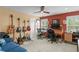 Eclectic bedroom with musical instruments, shutters, a large window and an inviting blue sofa at 1065 Cavan Dr, Apopka, FL 32703