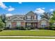 Charming two-story home featuring stone accents, red shutters, and a beautifully landscaped front yard at 1065 Cavan Dr, Apopka, FL 32703