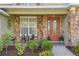 Inviting front porch with stone detail, quaint seating, and a decorative glass front door at 1065 Cavan Dr, Apopka, FL 32703