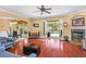 Bright living room with hardwood floors, fireplace, and french doors leading to the pool at 1065 Cavan Dr, Apopka, FL 32703