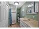 Bathroom featuring a white vanity, toilet, shower with blue accents, and decorative mirror at 1150 Virginia Avenue, Altamonte Springs, FL 32701