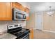 Clean kitchen with stove top oven, tile backsplash, wooden cabinets, and stainless steel microwave at 1150 Virginia Avenue, Altamonte Springs, FL 32701