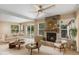 Cozy living room featuring a stone fireplace, natural light, and a ceiling fan at 1150 Virginia Avenue, Altamonte Springs, FL 32701