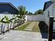 Fenced-in backyard featuring a walkway lined with plants and a large paved patio area at 1180 Baton Dr, Deltona, FL 32725