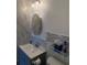 The bathroom features a gray vanity, a round mirror, and marble-look tile on the walls at 1180 Baton Dr, Deltona, FL 32725