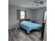 Cozy bedroom featuring a ceiling fan, a window for natural light, and wood-look laminate flooring at 1180 Baton Dr, Deltona, FL 32725