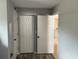 A hallway features a closet with folding doors and doorways leading to other rooms in the home at 1180 Baton Dr, Deltona, FL 32725