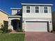 Charming two-story home with a two car garage, stone accents and manicured lawn at 1235 Island Slough Ln, Davenport, FL 33837