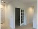 Bright hallway featuring neutral colors with a doorway to a room behind a glass paneled door at 1235 Island Slough Ln, Davenport, FL 33837