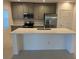Modern kitchen with stainless steel appliances, center island with sink, and white countertops at 1235 Island Slough Ln, Davenport, FL 33837