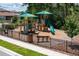 Community playground featuring play structures with slides, benches, and protective fencing at 1235 Island Slough Ln, Davenport, FL 33837