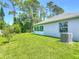 Lush green backyard featuring a well-kept lawn, perfect for outdoor activities and relaxation, near the enclosed sunroom at 1314 Victory Palm Dr, Edgewater, FL 32132