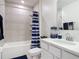 Neutral bathroom featuring a tub and shower, with a stylish blue and white striped shower curtain at 1314 Victory Palm Dr, Edgewater, FL 32132