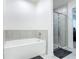 Bathroom featuring a neutral soaker tub, walk-in shower, neutral tile, and light walls at 1314 Victory Palm Dr, Edgewater, FL 32132