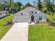 Charming single-story home features a manicured lawn, two-car garage, and neutral exterior paint at 1314 Victory Palm Dr, Edgewater, FL 32132
