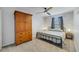 This carpeted bedroom features a ceiling fan, closet, and a stylish metal frame bed with an antique wood wardrobe at 1354 Riley Cir, Deland, FL 32724