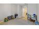 Bedroom with a gray rug, an open door to another room, and an assortment of toys at 1354 Riley Cir, Deland, FL 32724