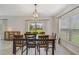 Dining room with tile flooring, a wooden table with six chairs, modern light fixture, and a sliding glass door at 1354 Riley Cir, Deland, FL 32724