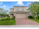Two-story home featuring a well-maintained lawn, a brick-paved driveway, and an attached two-car garage at 1354 Riley Cir, Deland, FL 32724