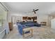 Open-concept living room with tile flooring, a large blue sofa, a ceiling fan, and connected to the kitchen and dining area at 1354 Riley Cir, Deland, FL 32724