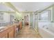 Bright main bathroom with dual sinks, granite countertops, a glass-enclosed shower, and a separate soaking tub at 1354 Riley Cir, Deland, FL 32724