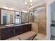 Elegant bathroom with double sink vanity, granite counters, decorative mirrors and tiled walk-in shower at 13798 Walcott Ave, Orlando, FL 32827