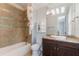 Bathroom with tiled shower-tub, granite countertop vanity and decorative mirror at 13798 Walcott Ave, Orlando, FL 32827