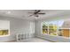 Bright bedroom with large windows, neutral carpet, and a modern ceiling fan at 13798 Walcott Ave, Orlando, FL 32827