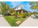 Inviting two-story home featuring a well-manicured lawn, vibrant landscaping, and a charming front porch at 13798 Walcott Ave, Orlando, FL 32827
