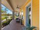 Charming front porch features brick flooring, seating, and a vibrant yellow exterior, creating a cozy and inviting atmosphere at 13798 Walcott Ave, Orlando, FL 32827