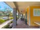 Relaxing front porch view featuring brick flooring, comfortable seating, and a charming yellow exterior at 13798 Walcott Ave, Orlando, FL 32827