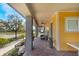 Relaxing front porch view featuring brick flooring, comfortable seating, and a charming yellow exterior at 13798 Walcott Ave, Orlando, FL 32827