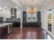 Open kitchen and dining area featuring custom cabinets, modern appliances, hardwood floors, and designer lighting at 13798 Walcott Ave, Orlando, FL 32827