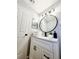 Charming bathroom vanity with granite top, black hardware and round mirror at 14521 Tanja King Blvd, Orlando, FL 32828