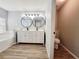 Bathroom featuring a double vanity, round mirrors, quartz countertops, soaking tub, and toilet closet at 14521 Tanja King Blvd, Orlando, FL 32828